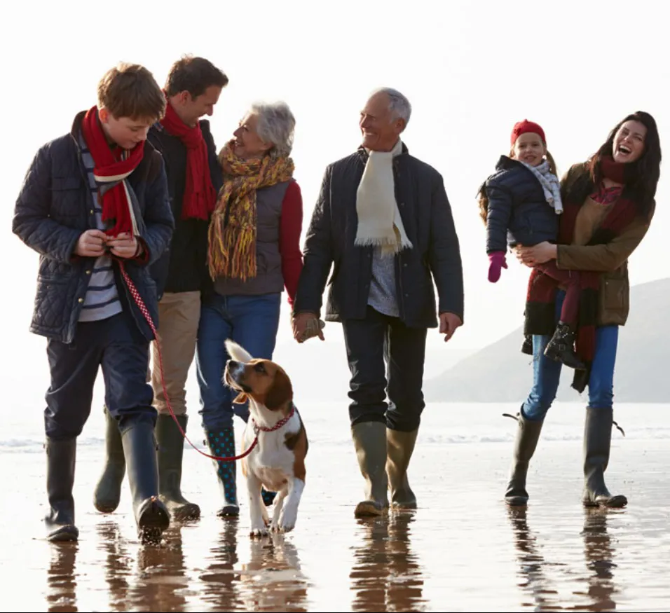 Three generations walking with dog on Brean Beach near Berrow on the Somerset coast